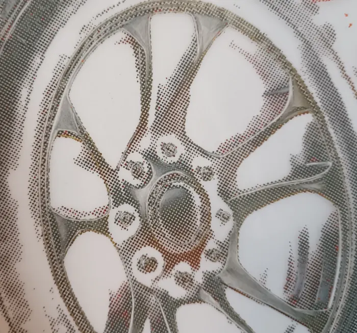 Macrophotographie d’une feuille de transfert DTF : une jante rendue entièrement en points d’encre séparés, sur le film translucide.