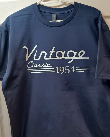 Chandail marine sur un cintre, portant un lettrage DTF crème d’une seule couleur : le mot Vintage en écriture cursive au-dessus de la mention Classic 1954.